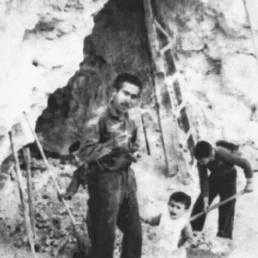 Imagen antigua de un hombre y dos niños trabajando en la cueva de La Gruta